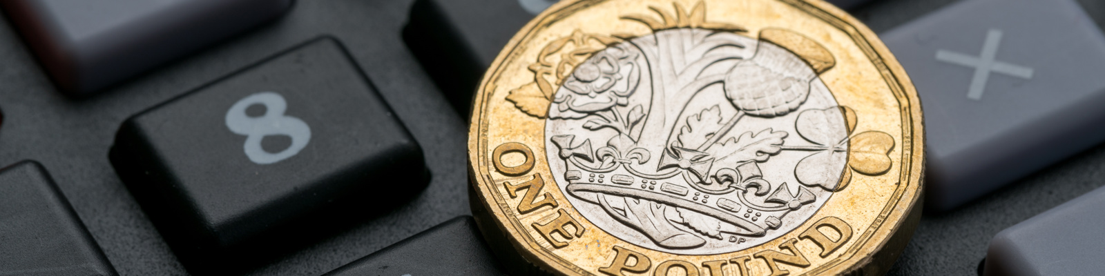 Photo of a £1 Coin Sitting on a Computer Keyboard.