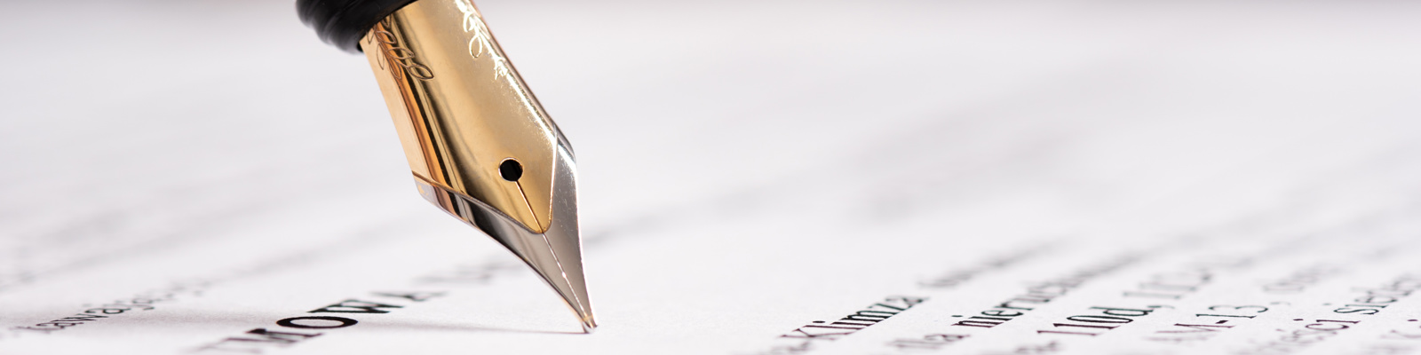 Photo of a fountain pen hovering above a written document.